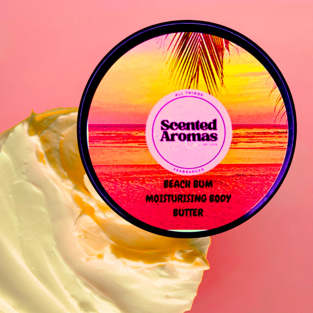 A container of "Brazilian Bum Cream Body Moisturising Butter 100ml" by The Soap Gal x sits against a pink backdrop, accompanied by creamy vegan lotion. The label features a sunset over a beach, capturing the essence of Brazilian Bum Cream.