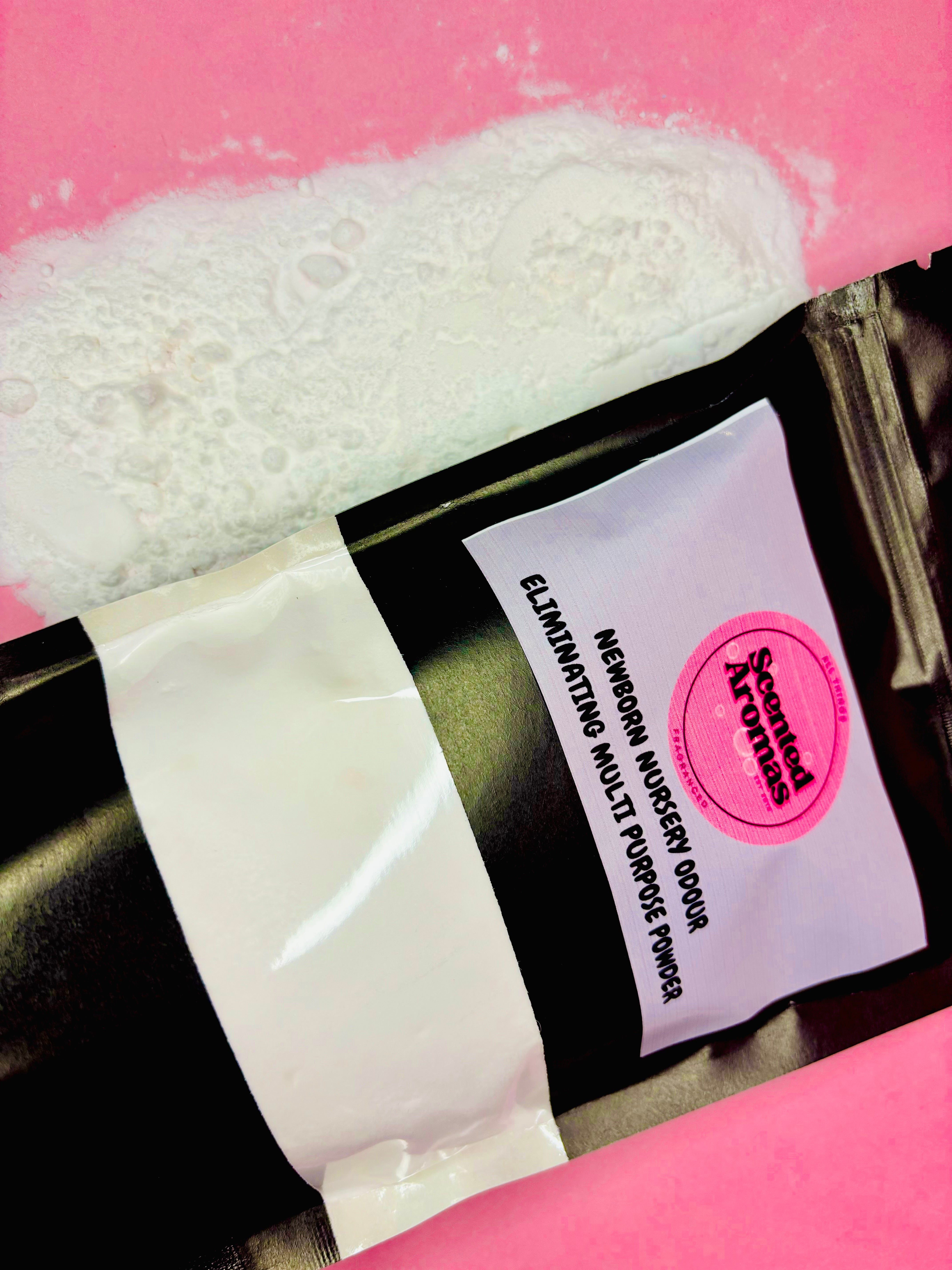 A black package labeled "The Soap Gal x" with powder spilling onto a pink surface, reminiscent of the Brazilian Bum Cream Multi Purpose Freshener 500g.