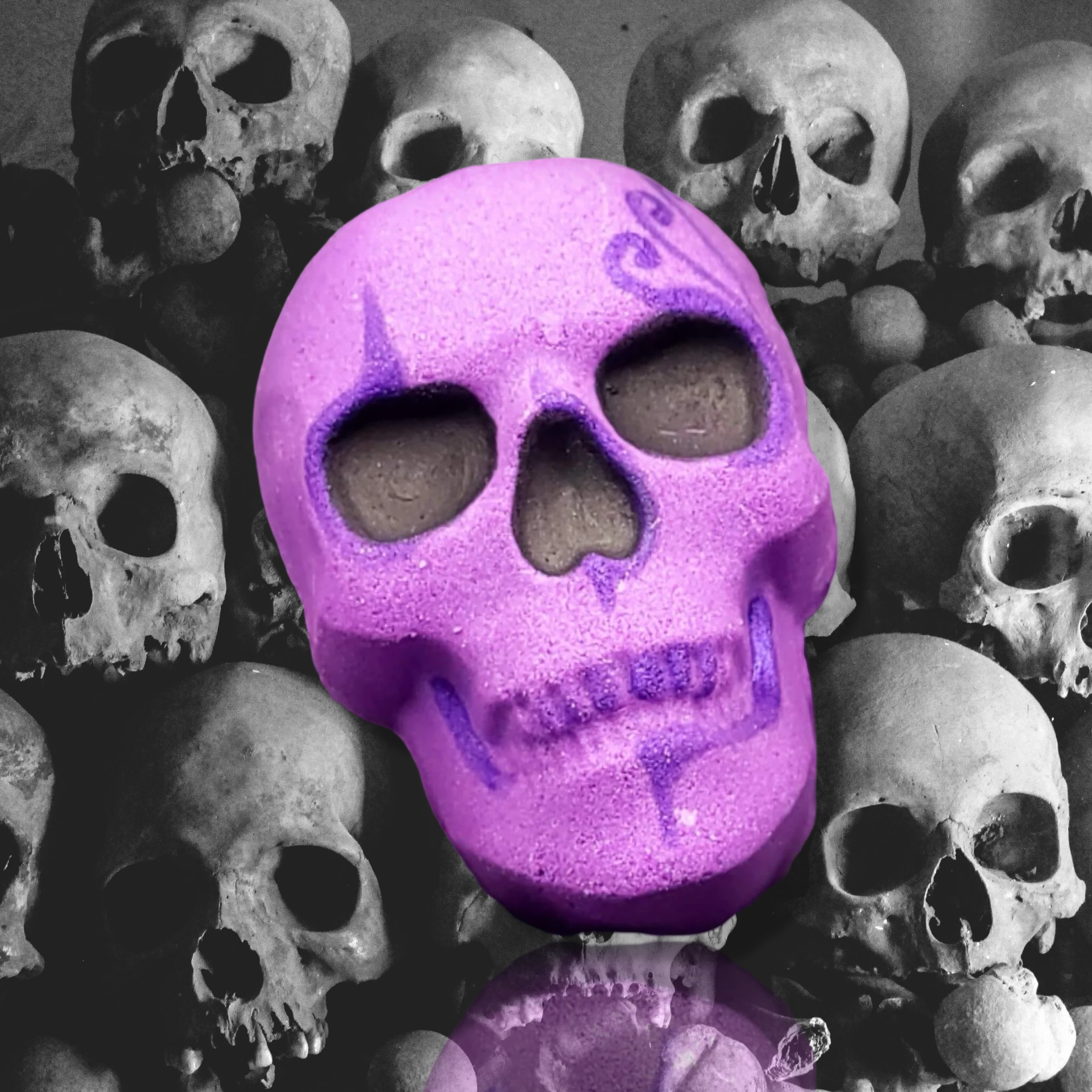 A limited edition purple skull adorned with intricate decorative markings stands out against a faded gray backdrop, capturing the mysterious allure of The Soap Gal x Imelda Skull Bath Bomb infused with the Pink Clouds fragrance.