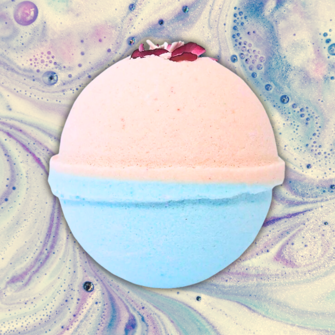 A round Cotton Candy Bath Bomb by The Soap Gal x, featuring a pink top half and blue bottom half, set against a marbled background of pastel colors, promises a refreshing bath experience with its sweet scent.