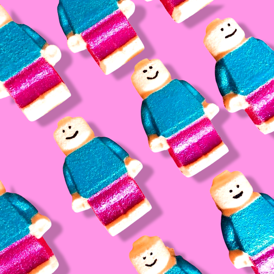 Several toy figures, resembling Brickman Figurine Mini Bath Bombs from The Soap Gal x, with their smiley faces, blue shirts, and pink pants, are arranged diagonally on a pink background. The scene exudes a whimsical charm reminiscent of a sweet red berry fragrance.