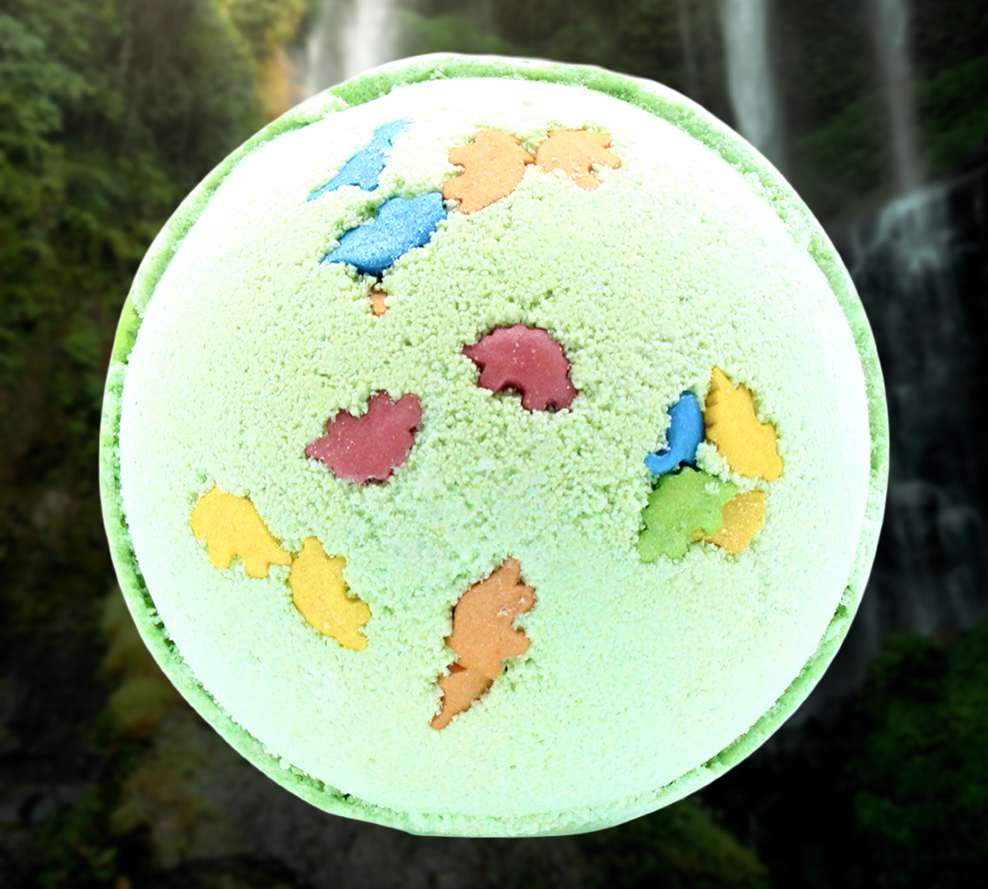 A close-up of a round, green Bath-o-saurus 3D Dinosaur Bath Bomb by The Soap Gal x, adorned with colorful dinosaur-shaped accents on its surface, resembles a delightful treat.