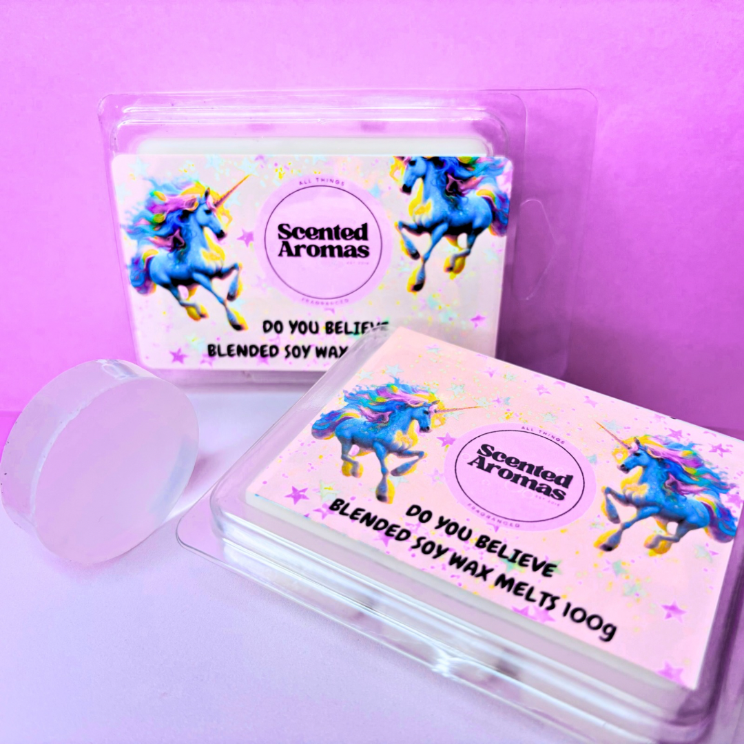 Two packages of "Do You Believe In Magic" soy wax melts by The Soap Gal x, adorned with a unicorn design, offer a long-lasting fragrance. These beautifully crafted soy wax blend melts are showcased against a pink background.