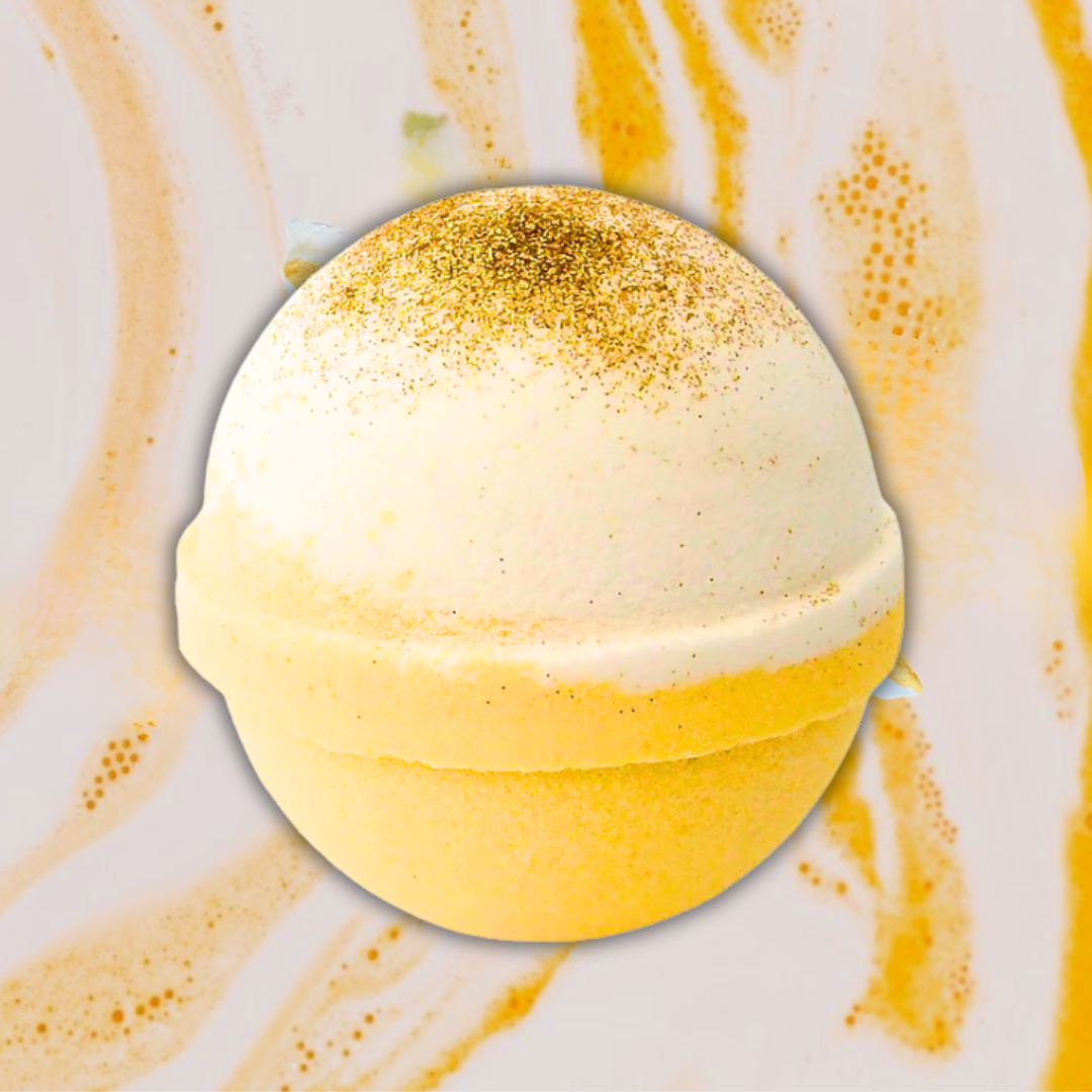 The Karma Glitzy Vegas Bath Bomb by The Soap Gal x offers a luxurious bath experience with its spherical design, featuring a glittery gold top half and solid yellow bottom half against a marble-like background. Immerse yourself in its fruity and floral aromas as it transforms your bath into an indulgent escape.